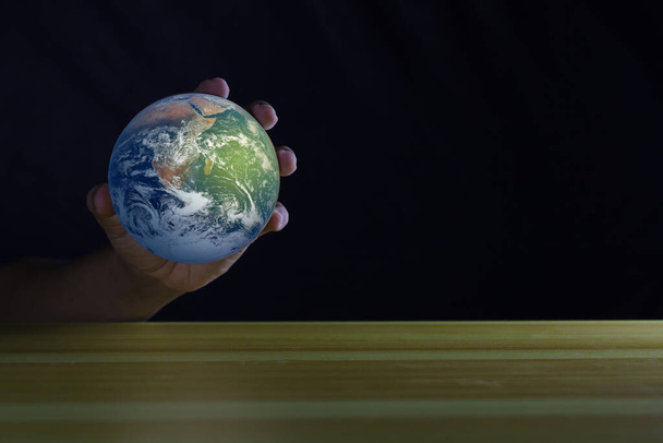 Globe in  hand on with empty table. - Photo, image