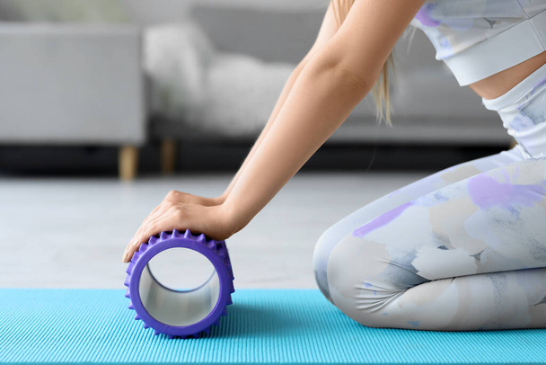 Young woman training with foam roller at home, closeup - Zdjęcie, obraz