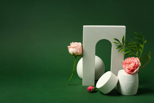 Decorative plaster podiums and flowers on green background - Fotoğraf, Görsel