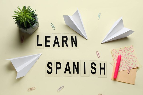 Text LEARN SPANISH, papírnictví, květináče a papírové roviny na béžovém pozadí - Fotografie, Obrázek