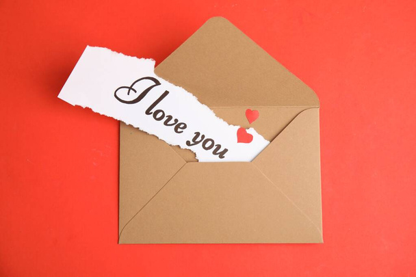 Sheet of paper with phrase I Love You in envelope on red background, top view - Foto, Bild