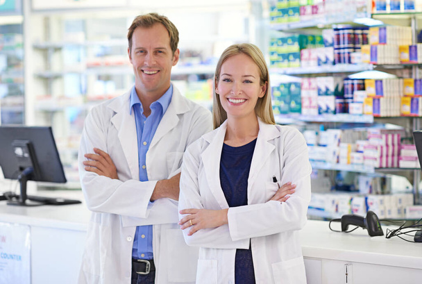 Farmacisti - Qui per aiutare. Ritratto di due farmacisti in piedi al banco delle ricette - Foto, immagini