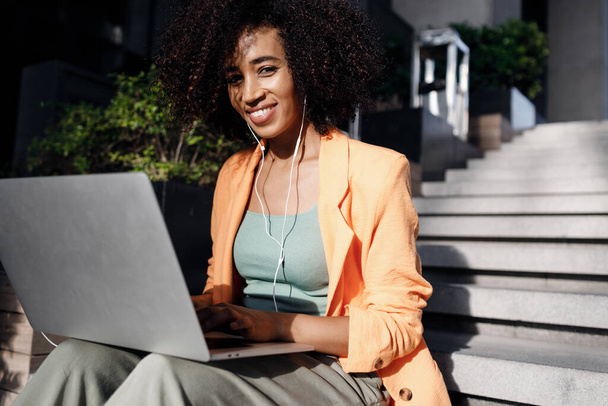 afro woman using laptop outdoor. High-quality photo - Φωτογραφία, εικόνα