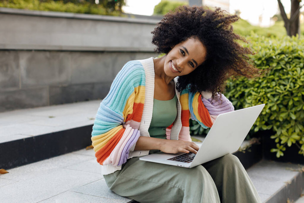 fekete bőrű nő laptoppal a szabadban. Kiváló minőségű fénykép - Fotó, kép