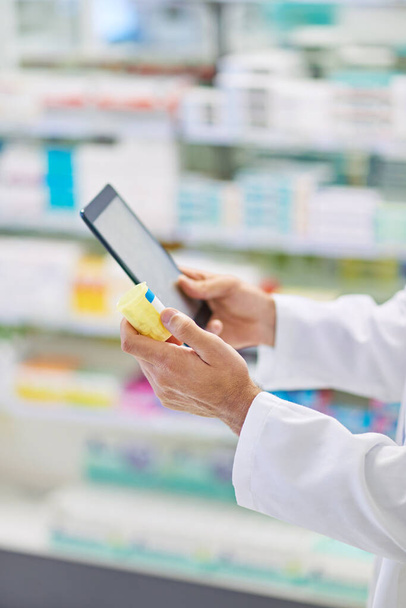Lets see what the internet says. A pharmacist working on a digital tablet - Photo, Image