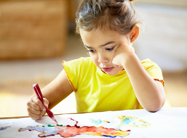 Δεν υπάρχει όριο στη φαντασία των παιδιών. Ένα αξιολάτρευτο κοριτσάκι που τα κάνει χάλια ενώ ζωγραφίζει. - Φωτογραφία, εικόνα
