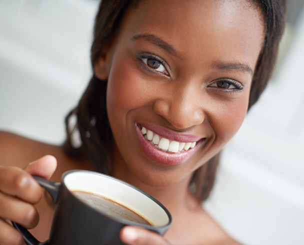 Ik begin haar ochtend. Een jonge etnische vrouw genieten van een kopje koffie - Foto, afbeelding