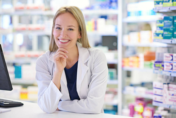 私の顧客が良くなるのを助けることは最高の気分です。処方箋カウンターに立つ魅力的な薬剤師の肖像 - 写真・画像