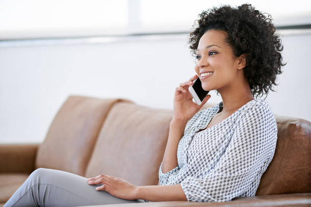 Приємного спілкування з другом. приваблива жінка говорить на своєму мобільному телефоні, сидячи на дивані
 - Фото, зображення