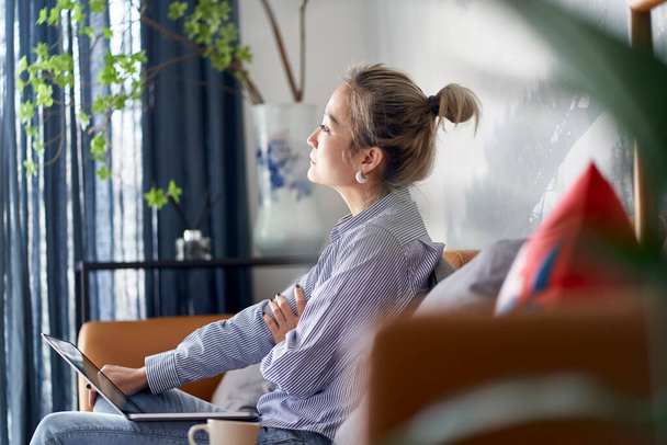 maduro profissional asiático mulher de negócios contemplando enquanto trabalhava em casa usando computador portátil, vista lateral - Foto, Imagem