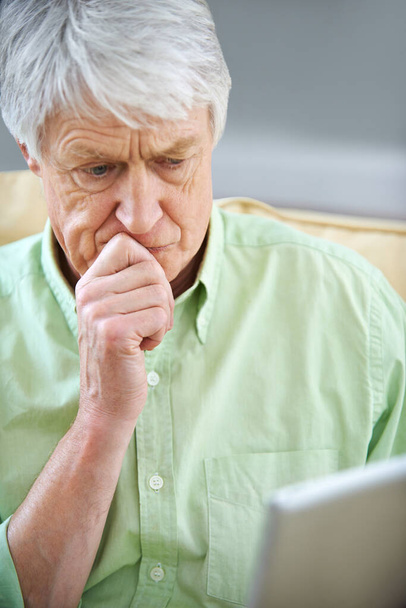 Λοιπόν αυτό είναι νέο... ένας ηλικιωμένος άνδρας με βαθύ βλέμμα στοχαστικό ενώ χρησιμοποιεί ένα ψηφιακό tablet - Φωτογραφία, εικόνα