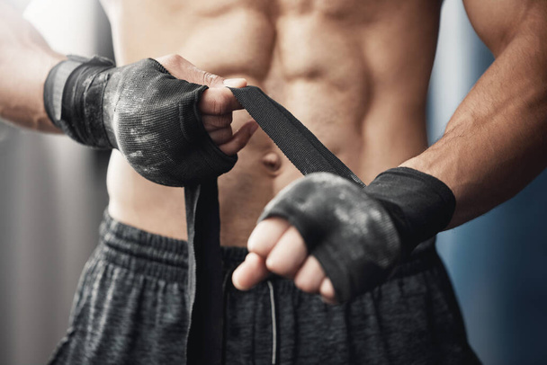 Εκπαίδευση, γυμναστήριο και πυγμαχία άνθρωπος προετοιμασία για προπόνηση ή αγώνα στο γυμναστήριο ή γυμναστήριο με περιτύλιγμα στο χέρι. Κοντινό πλάνο του αθλητικού μποξέρ ετοιμάζεται για δύναμη, καρδιο και αντοχή kickboxing πρόκληση. - Φωτογραφία, εικόνα