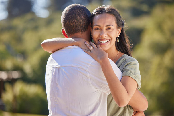 Couple, love bond and hug after an engagement with wedding ring jewellery in nature, environment and peace park. Portrait of smile, happy or safety security in marriage between man and woman in trust. - Фото, изображение