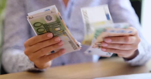 Крупный план женских рук, держащих и считающих банкноты евро. Денежные евро разных номиналов в руках женщины - Кадры, видео