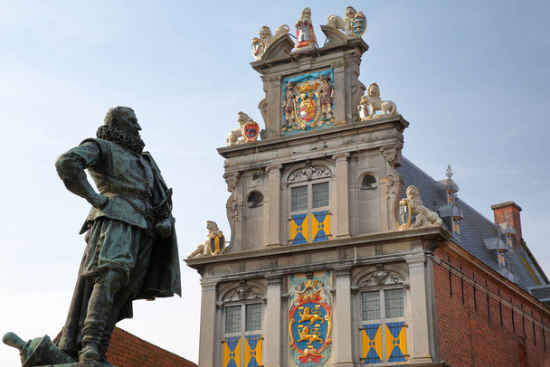 Close-up van het standbeeld van Jan Pieterszoon Coen (1587, 1629) in Hoorn, West-Friesland, Nederland, met de historische gevel van Statencollege (17 eeuws gebouw) op de achtergrond. Het standbeeld werd onthuld in 1893.. - Foto, afbeelding