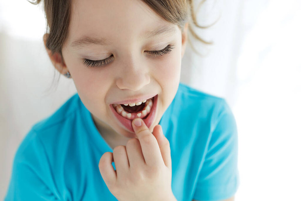 The child has lost a tooth. Little girl without a tooth. The first tooth fell out. High quality photo - Valokuva, kuva