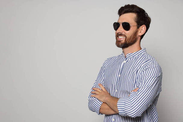 Portrait of smiling bearded man with sunglasses on grey background. Space for text - Fotoğraf, Görsel