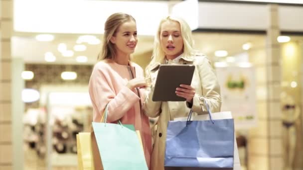 happy young women with tablet pc and shopping bags - Video, Çekim