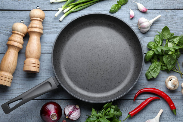 Flat lay composition with frying pan and fresh products on grey wooden table - Fotoğraf, Görsel