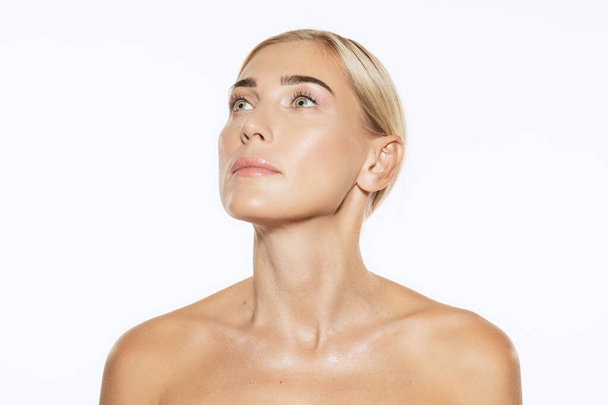 Pretty neck. Half-length portrait of young beautiful female fashion model with nude makeup isolated on white background. Beauty, spa, massage, face lifting and skin care concept - Φωτογραφία, εικόνα