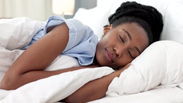 Sleep, bed and relax with a black woman sleeping in the bedroom of her home and dreaming. Resting, relaxing and peace with a young female lying on a pillow and under a duvet in a house in the morning. - Footage, Video