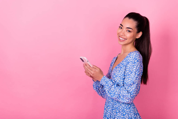 Closeup photo of young smiling businesswoman lady holding phone chatting online camera isolated on pink color background. - Foto, Imagen