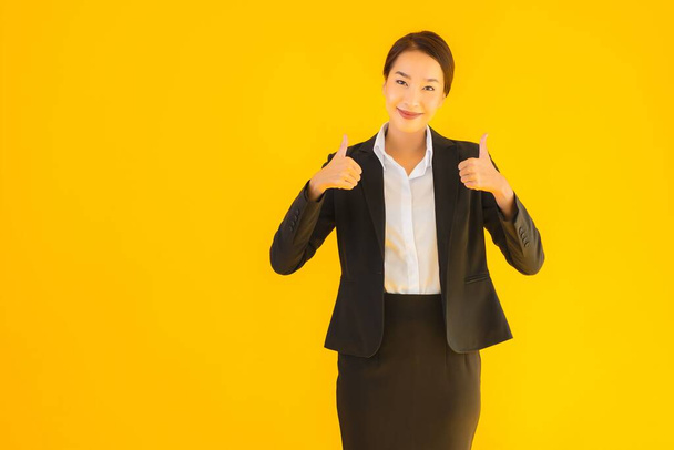 Beautiful portrait young business asian woman happy smile in many action on yellow isolated background - Fotó, kép