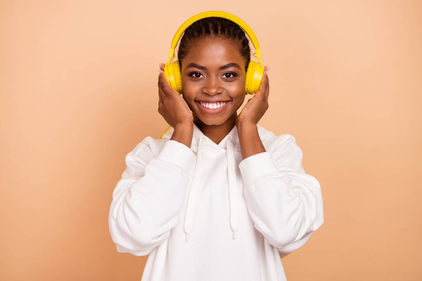 Photo of nice young brunette lady wear earphones hoodie isolated on beige color background. - Fotoğraf, Görsel