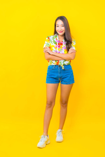 Ritratto bella giovane donna asiatica indossare camicia colorata su sfondo giallo per sonkran festival in Thailandia - Foto, immagini