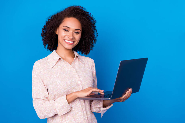 Portrait of pretty cheerful girl hands hold wireless netbook networking isolated on blue color background. - Foto, imagen
