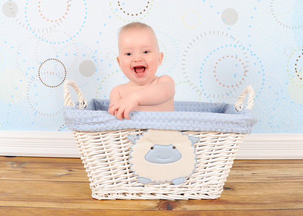 Bébé garçon enthousiaste en panier en osier bleu
 - Photo, image