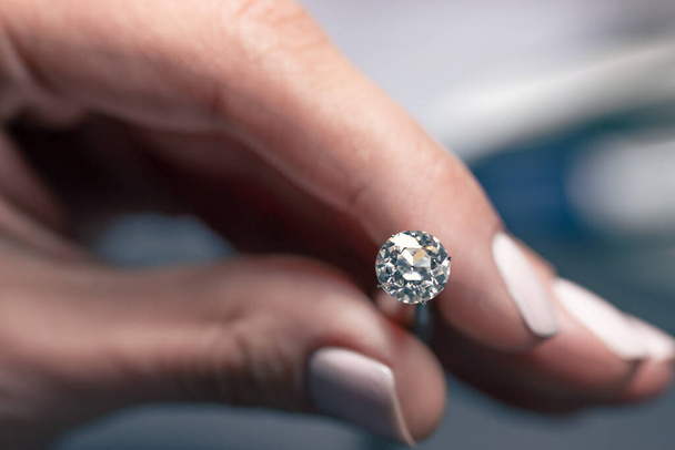 Woman Holding a Diamond With Tweezers - Foto, afbeelding