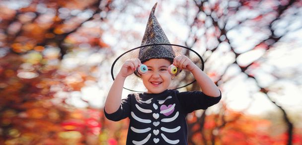 Young girl in black costume goes trick or treating. Little witch, Kids with jack-o-lantern. Children with candy bucket in fall forest. Happy Halloween. - Φωτογραφία, εικόνα