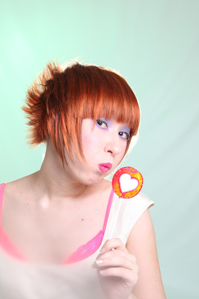 Redhead girl with lollipop heart vertically - Zdjęcie, obraz