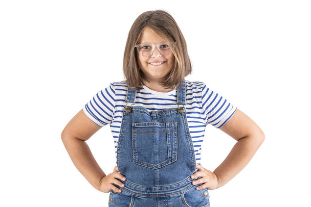Young brown-haired girl in glasses stands with her hands on hips smiling to the camera. - Foto, Imagem