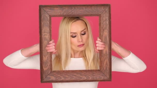 Mujer seductora enmarcando su cara en un marco
 - Imágenes, Vídeo