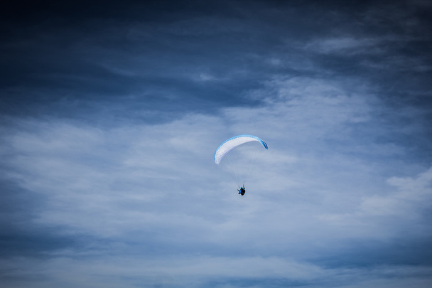 青い空にそびえ立つパラグライダー - 写真・画像