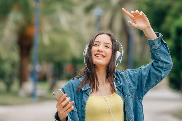 girl with headphones dancing in the street happy - Foto, imagen