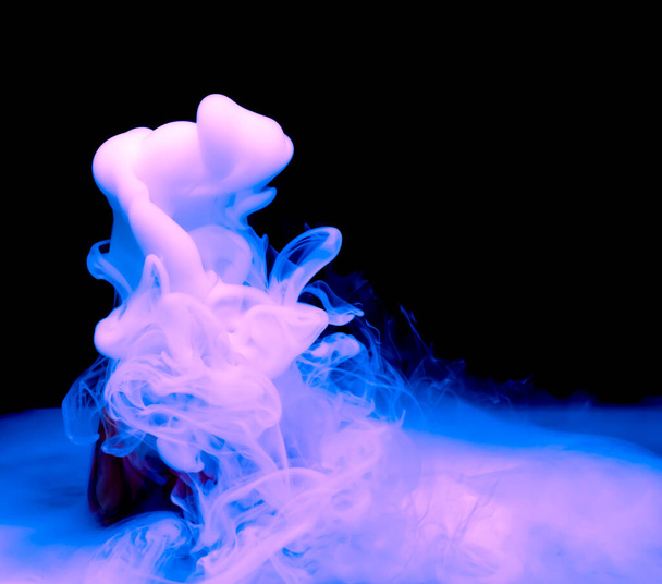 puffs of thick blue smoke against a black background - Фото, зображення