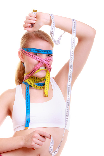 Obsessed fitness woman with a lot of colorful measure tapes - Photo, Image