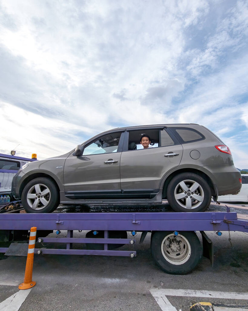 Perak, Malaysia - Aug 7, 2022 : Broken car on the truck with passenger to the workshop. - Photo, image