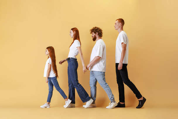 Diversity. Group of different ages redhead people wearing white tees and jeans posing isolated on yellow background. Emotions, friendship and active lifestyle. Look happy, delighted and cute - Photo, Image