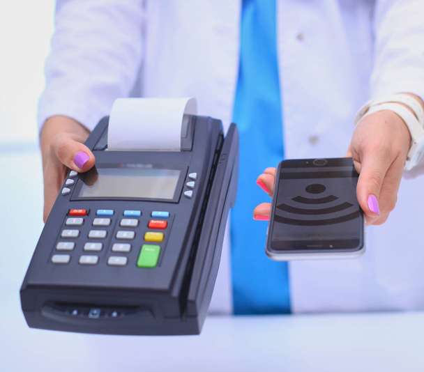Doctor is holding payment terminal in hands. Paying for health care. Doctor. - Fotografie, Obrázek
