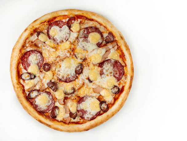 Pyszna pizza na białym tle. Świeża pizza z salami, kiełbasą i serem na białym tle. Przestrzeń kopiowania. Widok z góry - Zdjęcie, obraz