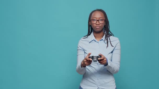 Afro-Amerikaanse vrouw het spelen van video games met controller, met behulp van tv-console om plezier te hebben met gameplay en online gaming concurrentie. Houdt joystick om actiegames te spelen op camera. - Video