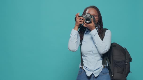 Vrouwelijke fotografe toerist maakt foto 's op vakantie, draagt rugzak en camera met lens. Fotograferen op vakantie, sightseeing en het vastleggen van foto 's, het maken van foto' s in studio. - Video