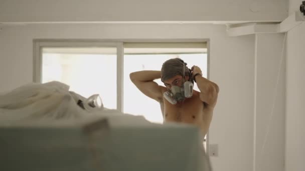 Hippi adam toz maskesi takıyor ve duvar zımpara kullanarak duvarları düzleştiriyor - 4K yatay video - Video, Çekim