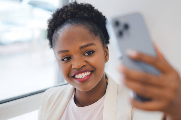 Jovem senhora de negócios preto tirar selfie no smartphone para as mídias sociais, se divertindo no café. Comunicação via Internet, tecnologia de conexão sem fio. Moderno - Foto, Imagem