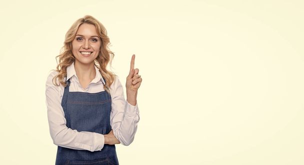 heureux barista femme dans tablier pointe doigt isolé sur fond blanc. - Photo, image