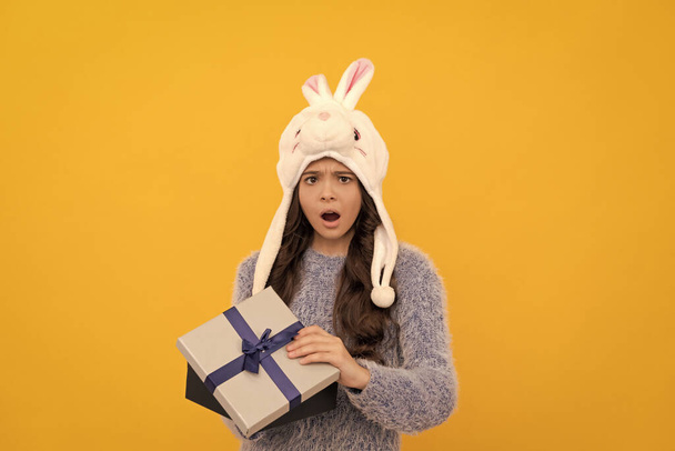 happy child in sweater and hat hold present box on yellow background, boxing day. - Foto, Imagem
